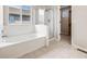 Bright bathroom with soaking tub, glass enclosed shower, and window at 11223 Jansen St, Parker, CO 80134