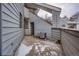 Exterior view of a gray home with a small patio area and staircase access at 17053 E Tennessee Dr # 101, Aurora, CO 80017