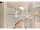 Bright kitchen featuring white appliances, white cabinetry, light countertops, and modern faucet at 17053 E Tennessee Dr # 101, Aurora, CO 80017
