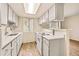 Bright kitchen featuring white cabinets and appliances, complemented by a modern countertop and ample natural light at 17053 E Tennessee Dr # 101, Aurora, CO 80017