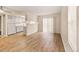 Bright living room featuring wood floors, sliding glass door, and an opening to the kitchen with white cabinets at 17053 E Tennessee Dr # 101, Aurora, CO 80017