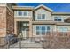 Charming two-story townhome with brick accents, inviting front porch, and outdoor seating area at 1817 S Buchanan Cir, Aurora, CO 80018