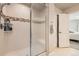 Shower showcasing decorative tiled accent, modern fixtures, and a glass door for a spa-like experience at 1817 S Buchanan Cir, Aurora, CO 80018