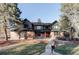Stunning two-story brick and dark siding home with mature trees and manicured lawn at 1 Winged Foot Way, Littleton, CO 80123