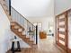 Inviting foyer with hardwood floors, staircase with black railings, and modern front door at 1 Winged Foot Way, Littleton, CO 80123
