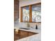 Gourmet kitchen featuring marble countertops, wood cabinets, a gold faucet and plenty of natural light at 1 Winged Foot Way, Littleton, CO 80123
