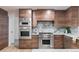 Modern kitchen with stainless steel appliances, marble countertops, and custom wood cabinetry for a sleek design at 1 Winged Foot Way, Littleton, CO 80123