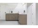 Bright and modern kitchenette with light wood cabinets, neutral countertops, and stainless steel hardware at 1 Winged Foot Way, Littleton, CO 80123