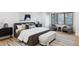 Comfortable main bedroom with a large upholstered bed, wood-trimmed windows, and minimalist decor at 1 Winged Foot Way, Littleton, CO 80123
