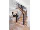 Elegant wooden staircase with black metal railings, connecting to an open-concept living space at 1 Winged Foot Way, Littleton, CO 80123