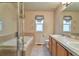 Bright bathroom featuring a shower, large soaking tub, vanity with dual sinks, and decorative window at 6731 E 128Th Pl, Thornton, CO 80602