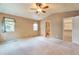 Spacious bedroom featuring neutral carpeting, a ceiling fan, vaulted ceiling, and access to an ensuite bathroom and walk-in closet at 6731 E 128Th Pl, Thornton, CO 80602