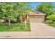 Charming single-Gathering home with brick facade, green lawn, mature trees, and a two-car garage at 6731 E 128Th Pl, Thornton, CO 80602