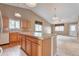 Open kitchen featuring a center island, light wood cabinets, tile countertops, and modern appliances at 6731 E 128Th Pl, Thornton, CO 80602