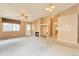 Open living room with a fireplace, high ceilings, neutral carpet, and access to the backyard at 6731 E 128Th Pl, Thornton, CO 80602