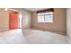 Bright living room with a large window, neutral carpet, light walls, and a coral front door at 6731 E 128Th Pl, Thornton, CO 80602