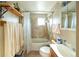 A tiled bathroom with a shower and tub combination, complemented by a single sink and vanity at 1075 S Ames St, Lakewood, CO 80226