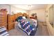 This bedroom has carpet, a large bed with a patterned quilt, wooden furniture, and a window at 1075 S Ames St, Lakewood, CO 80226