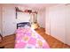 This bright bedroom features wood floors, natural light, a colorful quilt, and two closets at 1075 S Ames St, Lakewood, CO 80226