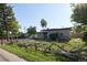 Street view of the home with wood fence and xeriscape landscaping features at 1075 S Ames St, Lakewood, CO 80226