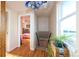 Sunlit hallway with hardwood floors leading to a bedroom and stairs to the basement at 1075 S Ames St, Lakewood, CO 80226