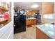 Bright kitchen with wood cabinets, stainless steel appliances, updated counters, and a black refrigerator at 1075 S Ames St, Lakewood, CO 80226