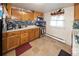 Well-lit kitchen featuring wood cabinets, sleek countertops, stainless steel appliances, and tiled flooring at 1075 S Ames St, Lakewood, CO 80226