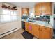Charming kitchen with wood cabinets, tiled backsplash, stainless steel sink, and cozy decor at 1075 S Ames St, Lakewood, CO 80226