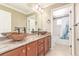 Bathroom with dual vessel sinks, granite counters, wood cabinetry, and a bathtub shower combo in the background at 1122 Orion Way, Castle Rock, CO 80108