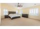 Bright bedroom with yellow walls, carpeted floors, a ceiling fan, and white shuttered windows at 1122 Orion Way, Castle Rock, CO 80108