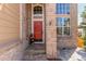 Inviting entryway with a vibrant red door, brick accents, and stone pathway at 1122 Orion Way, Castle Rock, CO 80108