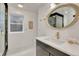 Stylish bathroom with unique oval mirror, modern vanity, and natural light from a window at 520 Columbine St, Denver, CO 80206