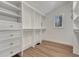 Walk-in closet featuring custom white shelving, drawers, and wood flooring at 520 Columbine St, Denver, CO 80206
