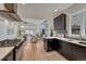 Open kitchen showcasing modern appliances, black cabinets, hardwood floors, and seamless flow into the living area at 520 Columbine St, Denver, CO 80206