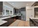 Well-lit kitchen featuring stainless appliances, black cabinetry, modern backsplash, and hardwood flooring at 520 Columbine St, Denver, CO 80206