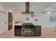 Kitchen island featuring bar seating, gas cooktop, stainless hood, and modern pendant lighting at 520 Columbine St, Denver, CO 80206