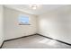 A vacant bedroom painted white features one window and neutral carpeting at 6298 S Harlan Way, Littleton, CO 80123