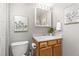 A well-lit bathroom with a decorative mirror, art, and light wood cabinetry at 970 S Dawson Way # 15, Aurora, CO 80012