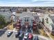 Exterior view of a multi-Gathering residential building with red staircases and a well maintained parking area at 970 S Dawson Way # 15, Aurora, CO 80012