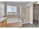 Primary bathroom with tub shower combination, glass shower door, and a large window at 10115 Foxridge Ct, Highlands Ranch, CO 80126
