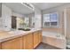 Double sink vanity, soaking tub, and a glass shower in primary bathroom with natural light at 10115 Foxridge Ct, Highlands Ranch, CO 80126