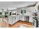 Modern kitchen and dining area featuring white cabinets, stainless appliances and hardwood floors at 10115 Foxridge Ct, Highlands Ranch, CO 80126