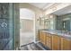 Stylish bathroom featuring wood floors, granite countertops, double sinks, and a glass shower enclosure at 20455 E Grand Ln, Aurora, CO 80015