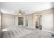 Large bedroom with plush carpeting and multiple entryways to the en suite bath and walk-in closet at 20455 E Grand Ln, Aurora, CO 80015