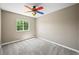 Neutral bedroom with a colorful fan, natural light from a window, and plush gray carpet at 20455 E Grand Ln, Aurora, CO 80015