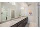 Elegant bathroom with dual sinks, a large mirror, modern fixtures, and a walk-in shower at 9072 E 47Th Ave, Denver, CO 80238