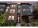 Charming townhome featuring a modern facade with brick accents, large windows, and inviting front steps at 9072 E 47Th Ave, Denver, CO 80238
