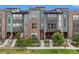 Modern townhome with a stylish brick and siding exterior, showcasing a well-maintained front yard at 9072 E 47Th Ave, Denver, CO 80238