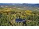 Aerial view of mountain home surrounded by colorful fall foliage at 10756 Timothys Dr, Conifer, CO 80433