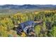 Mountain home with entertainment deck surrounded by trees and foliage at 10756 Timothys Dr, Conifer, CO 80433